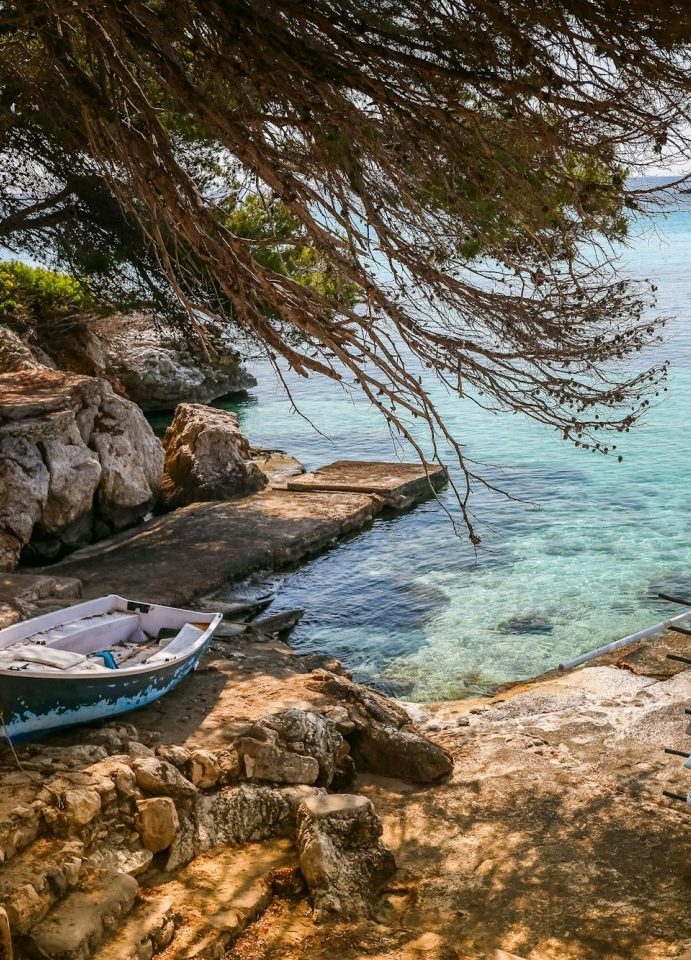 Ein ruhiger Blick auf den Strand Estellencs auf Mallorca mit einem kleinen Boot