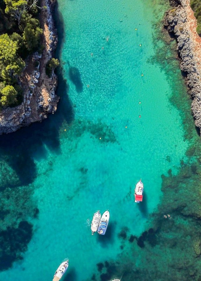 Boote im türkisblauen Wasser in Cala Llombards Mallorca