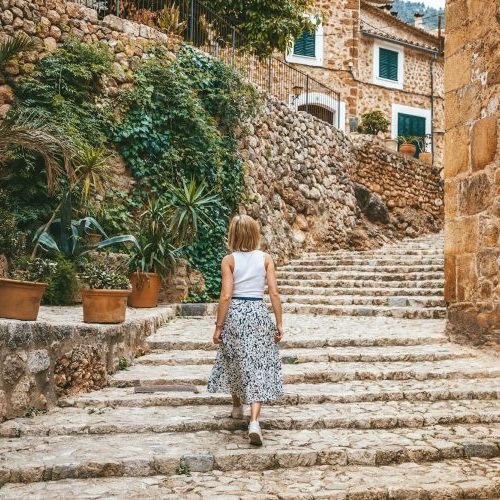 Frau auf einer Treppe in einer malerischen Straße der Stadt Felanitx